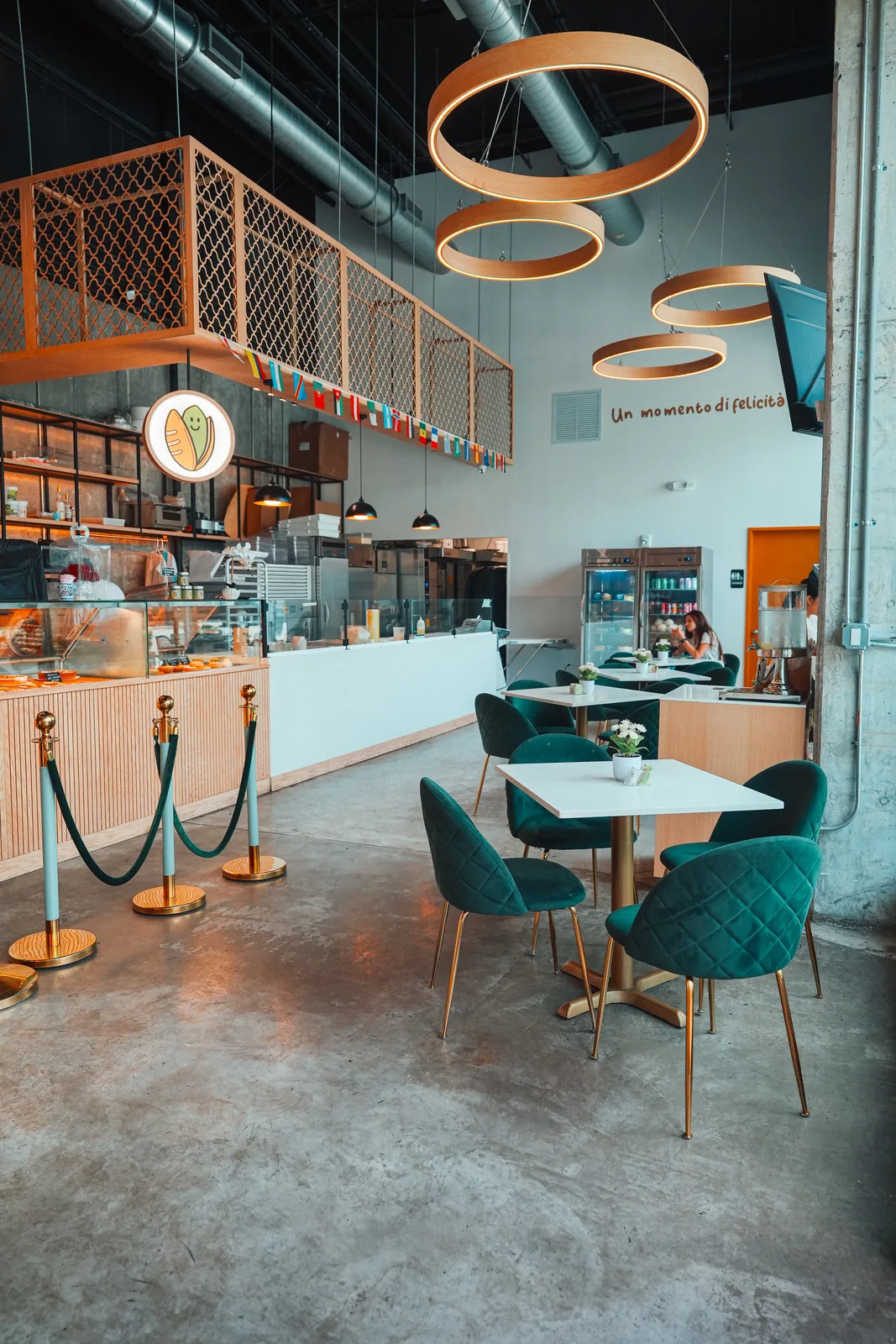 Interior de Pistacchio Pane e Caffe con mesas y sillas de terciopelo verde